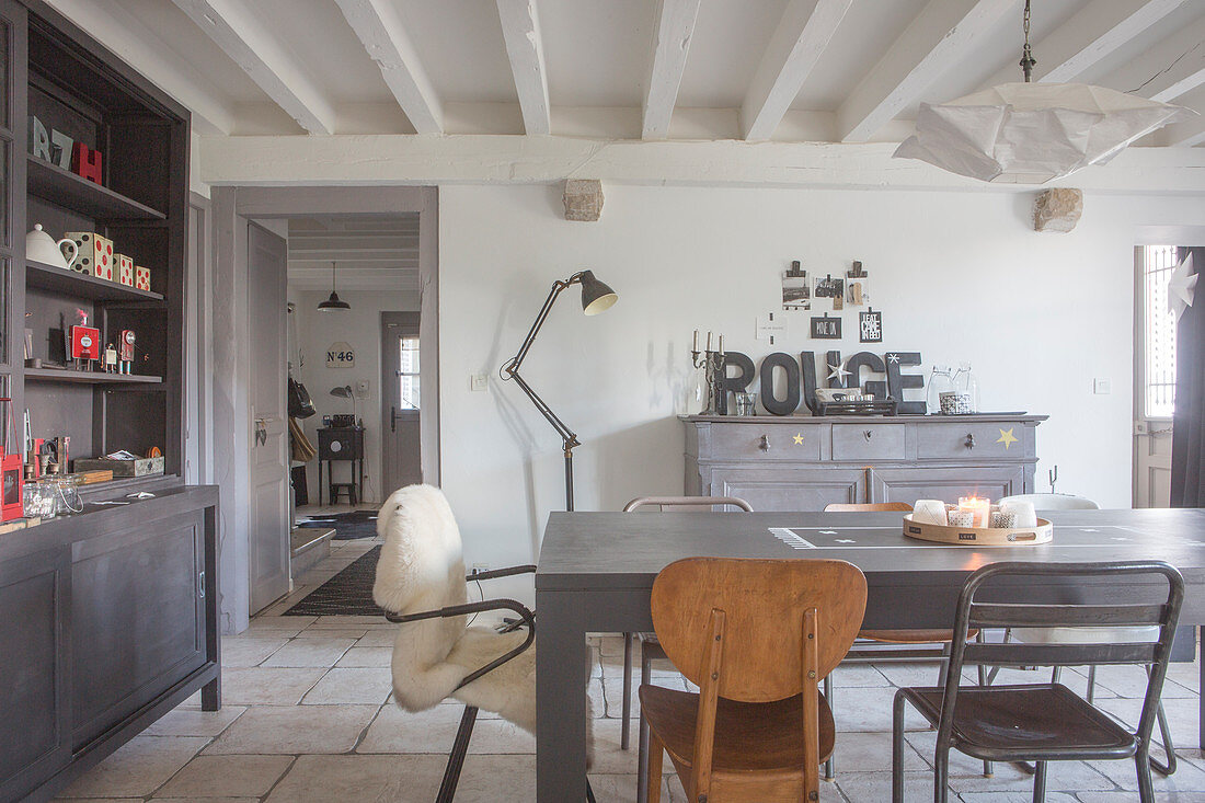 Grauer Esstisch mit Retro Stühlen und grau Anrichte im Esszimmer mit Holzbalkendecke