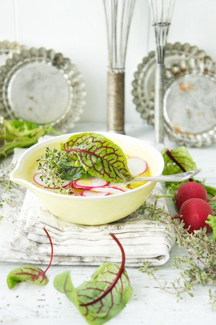 Radish leaf soup garnished with radishes, thyme and lettuce