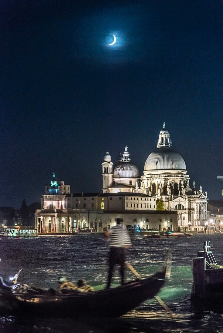 An moonlit, evening gondola ride with the church of Santa Maria della Salute, Venice, Italy