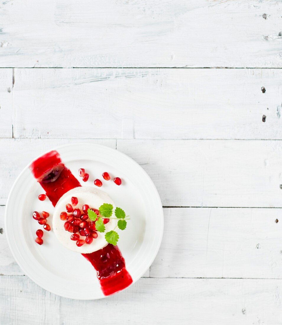 Panna cotta with a pomegranate sauce and pomegranate seeds