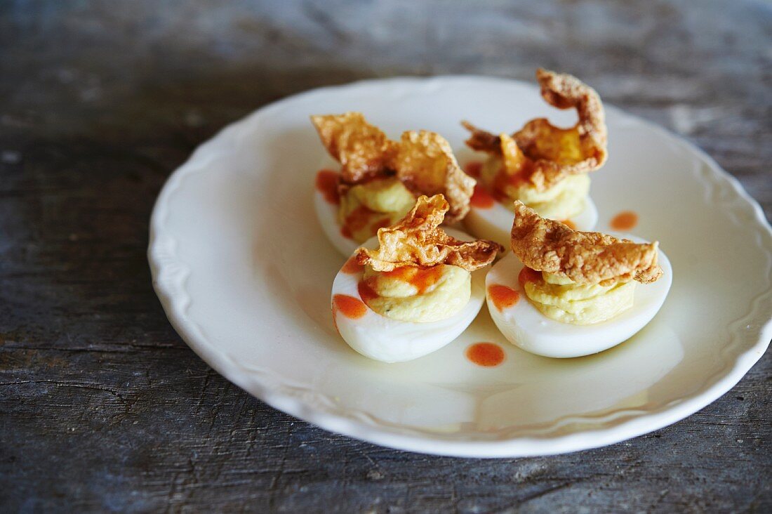 Devilled eggs with hot sauce and pork scratchings