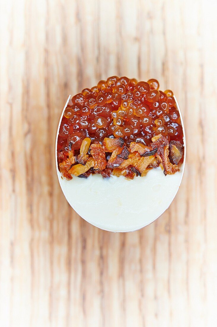 A cross-section of a devilled egg filled with lemon cream, fried shiitake mushrooms, bonito caviar and maple syrup