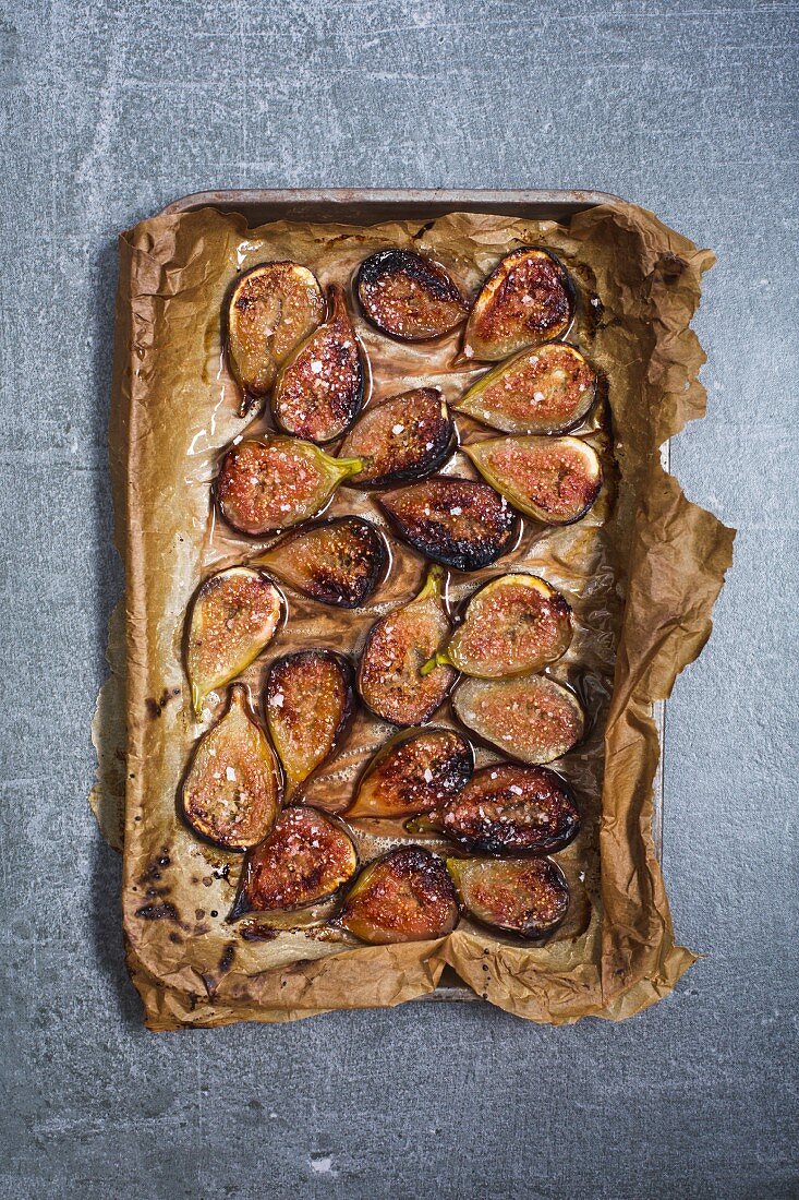 Baked figs with salted honey on a baking tray (seen from above)