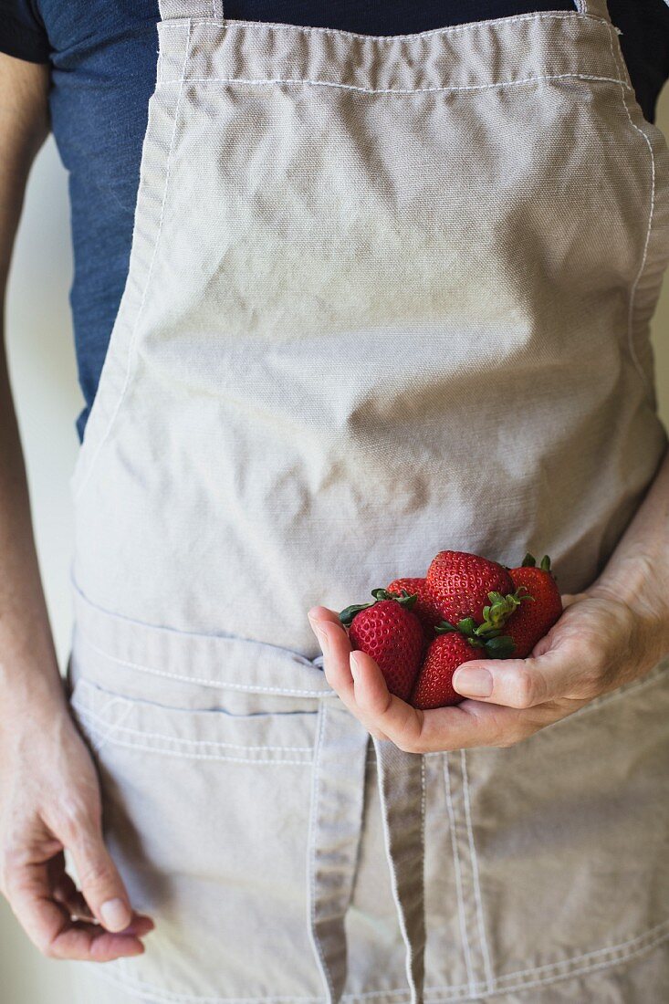 Person hält frische Erdbeeren