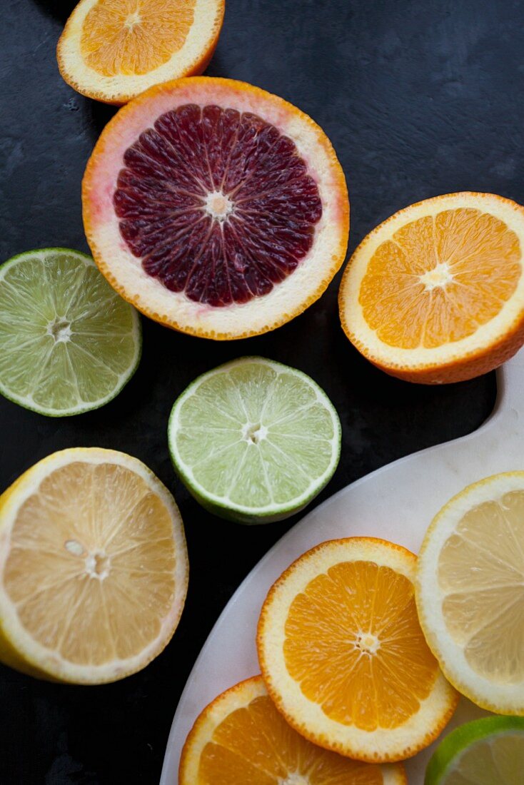 Various types of citrus fruits, sliced and halved (seen above)