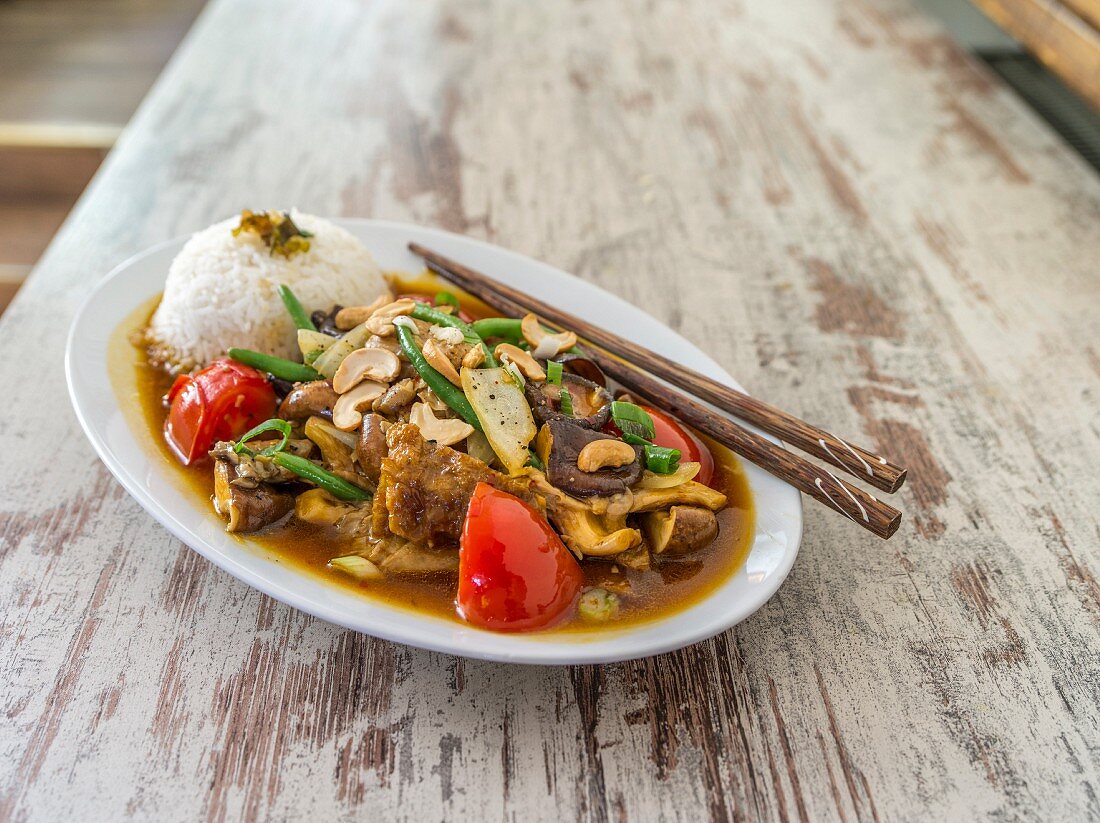 Chicken with mushrooms, cashew nuts, tomatoes, beans and rice (Asia)