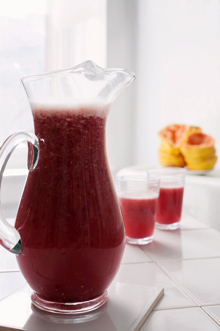 Freshly pressed grapefruit and pomegranate juice in a glass jug