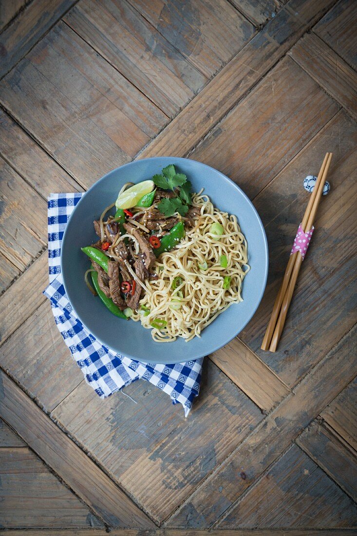 Fried noodles with beef, mange tout, sesame seed and spring onions (Asia)