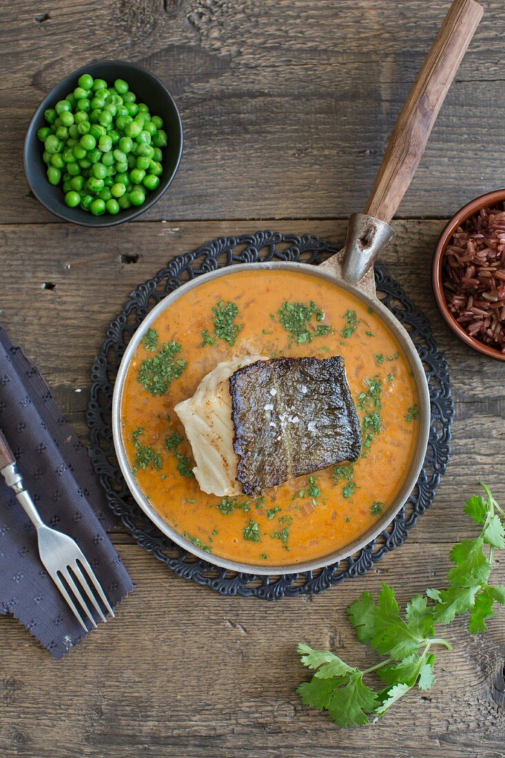 Red cod curry with peas and red rice