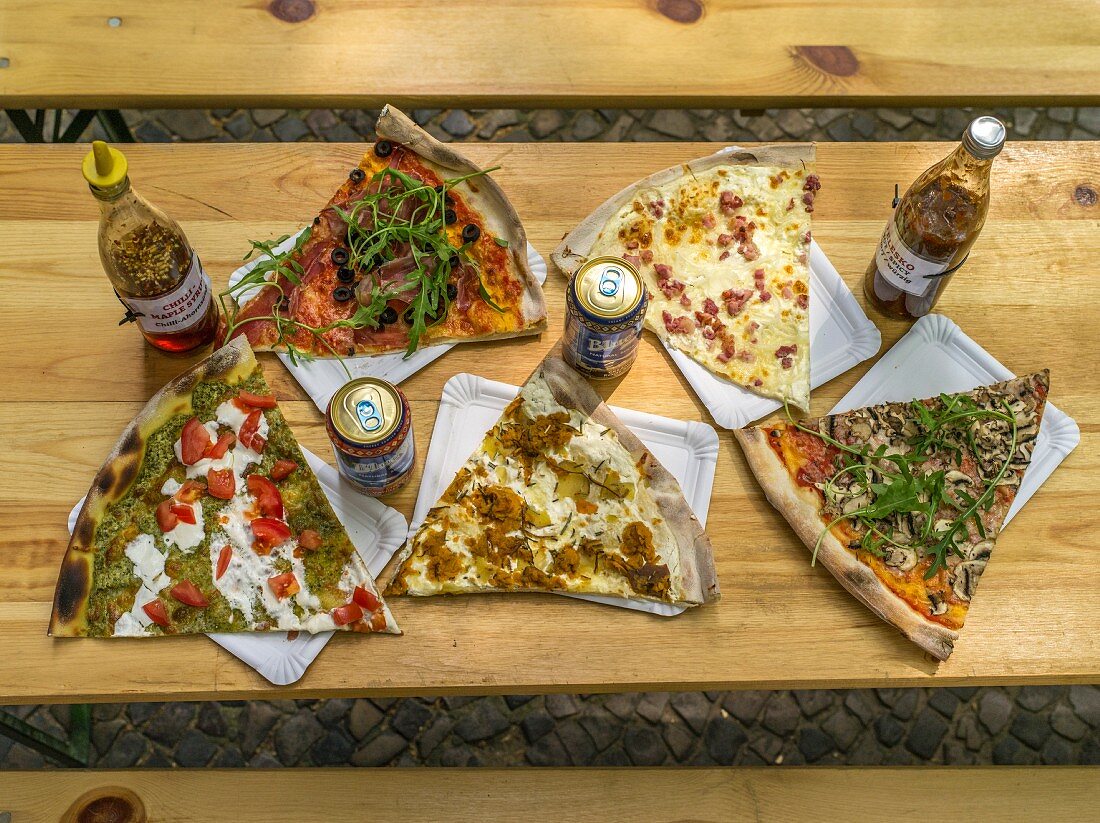 Various slices of pizza on a rustic wooden table