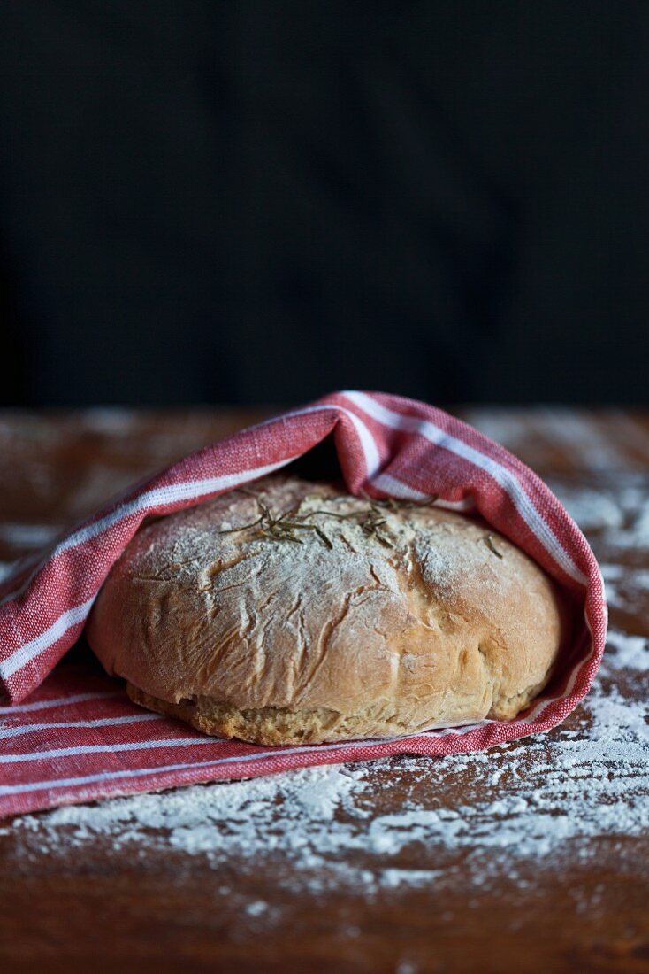 Freshly baked bread in a tea towel