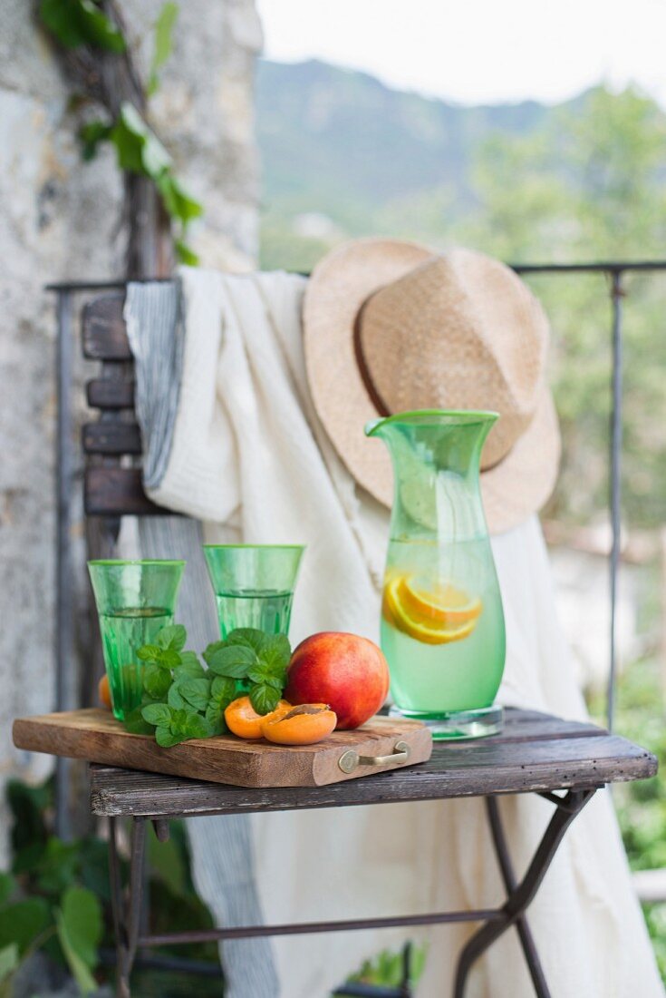 Obst und Limonade auf Holzstuhl am Balkon (Italien)