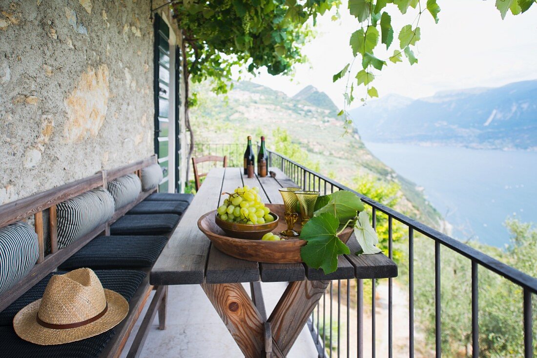 Trauben und Rotwein auf Balkon mit Seeblick (Italien)