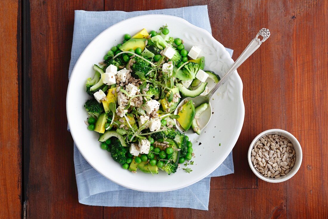 Broccoli and avocado salad with cucumber, peas, feta cheese and beansprouts