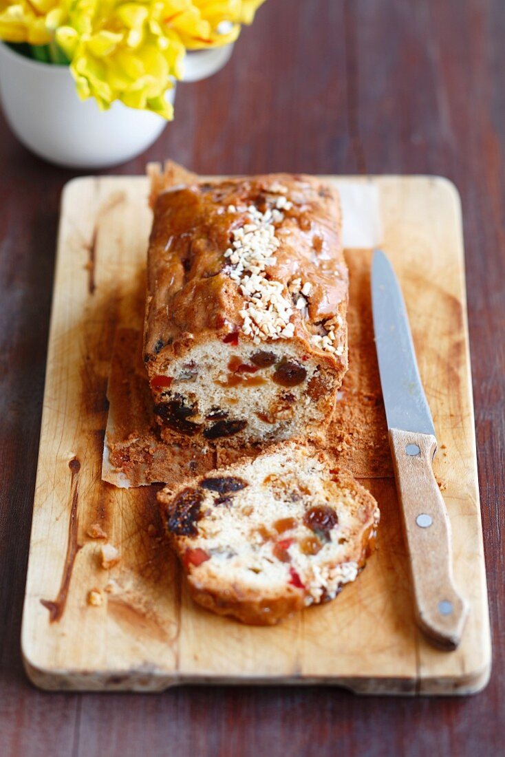 Fruit cake, partly sliced, on chopping board