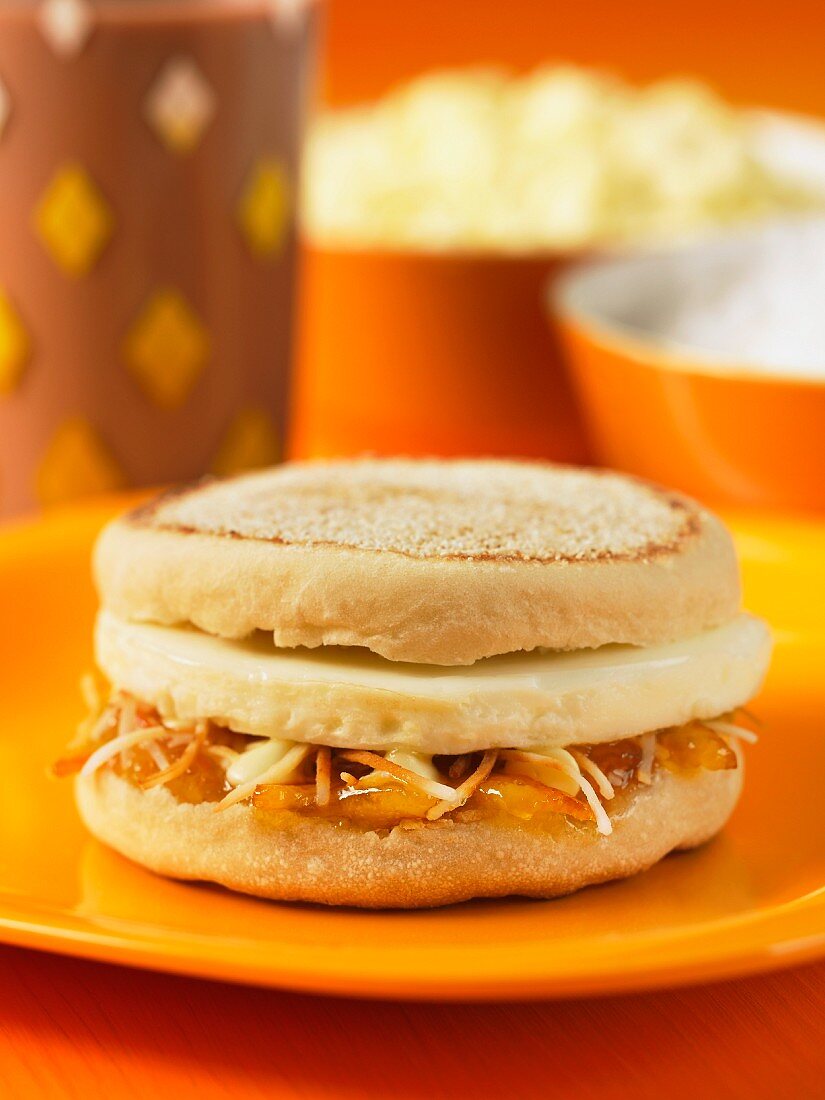 An English muffin with marmalade and Cheddar cheese