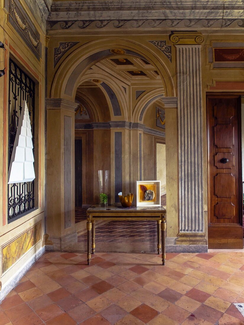 Foyer of palazzo with trompe l'oeil fresco and terracotta floor