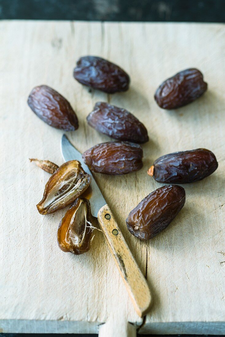 Fresh dates on a wooden board with a knife