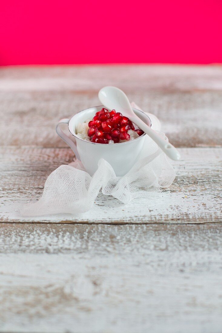 Coconut rice pudding with pomegranate seeds in a cup