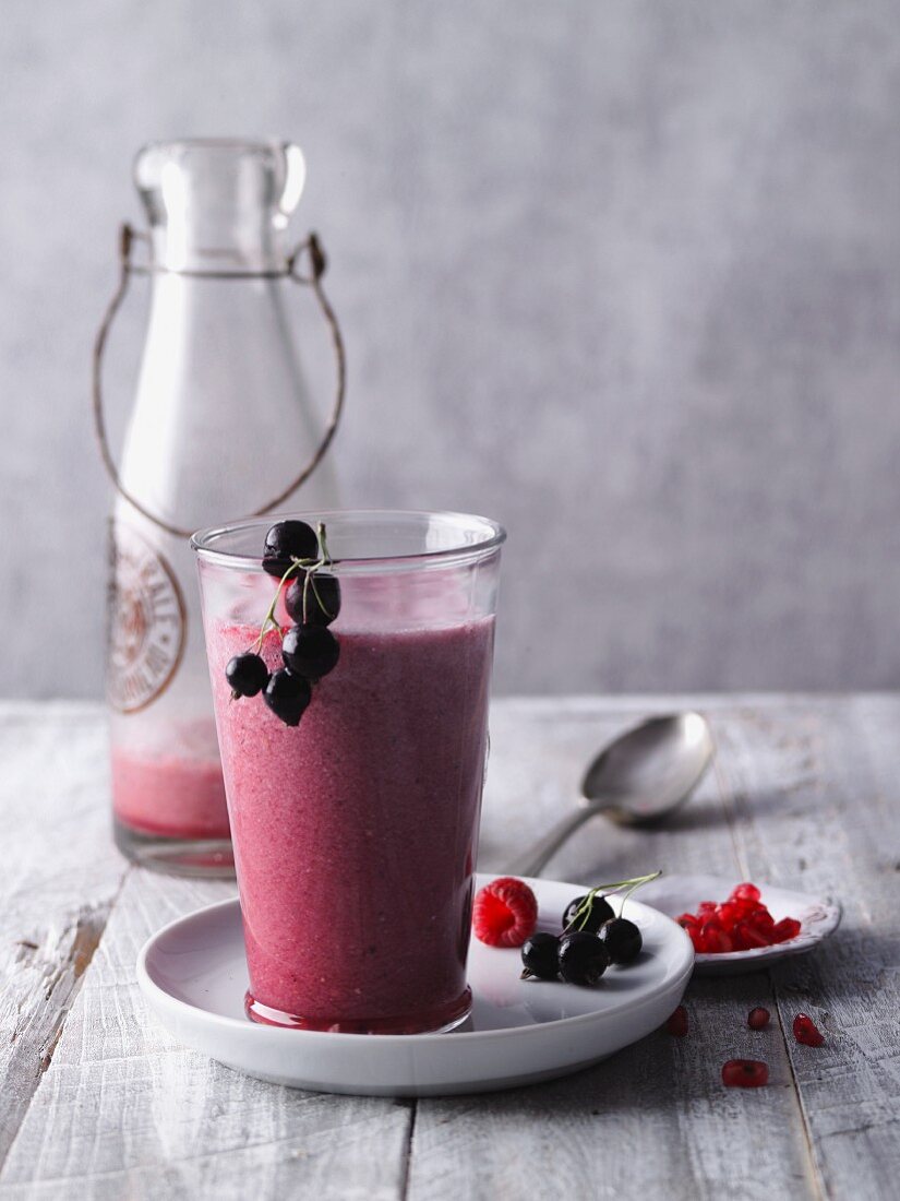 Roter Beeren-Smoothie mit Granatapfel, Pfirsich und Acaipulver