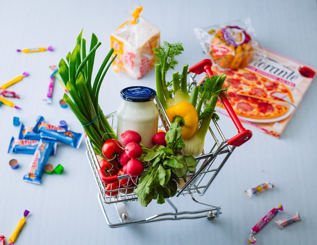 A doll's shopping trolley with mini foods