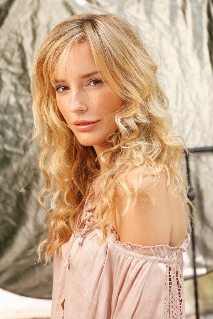 A young woman wearing a white blouse with one shoulder bare