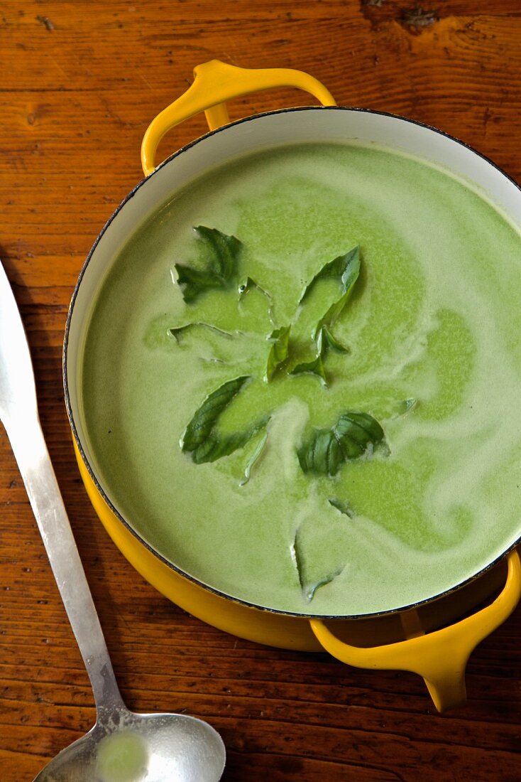 Pea soup with basil in a pot
