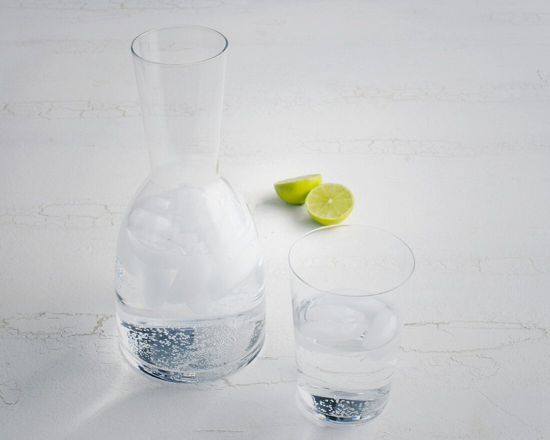 A carafe of water and limes