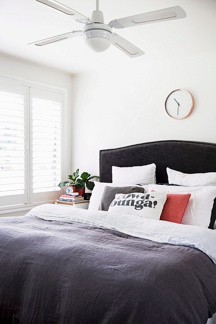 Schlafzimmer mit Decken-Ventilator, viele Kissen auf dem Bett