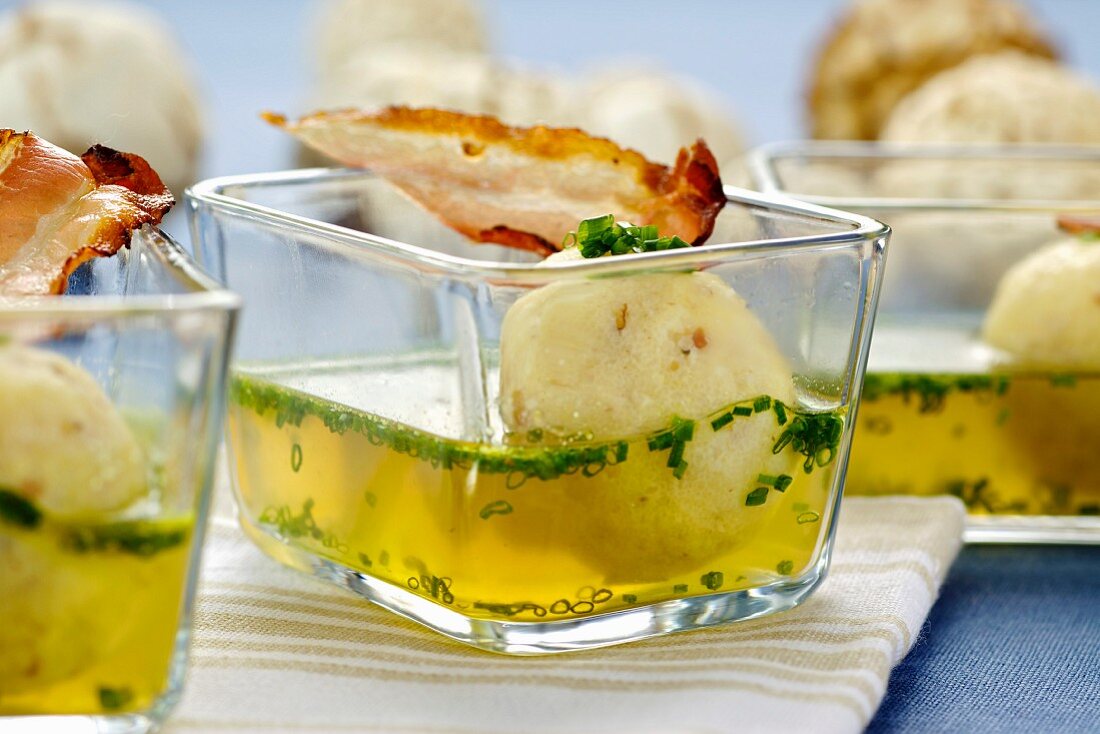 Soup with bacon and semolina dumplings in small glass bowls
