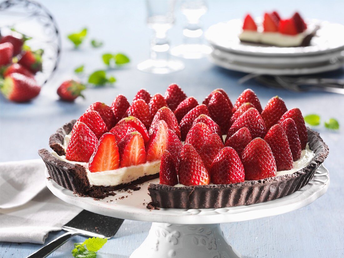 Strawberry tart, sliced, on a cake stand