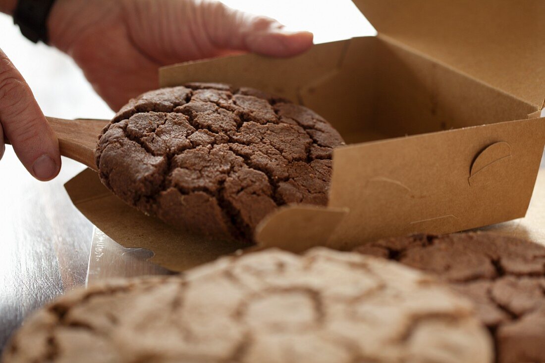 Mann gibt Chocolatechip Cookie in eine Schachtel