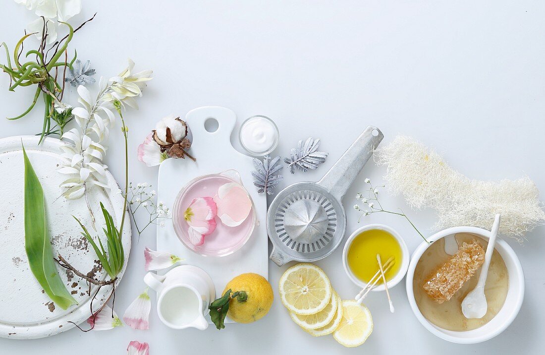 An arrangement of flowers, lemons, oil and honey