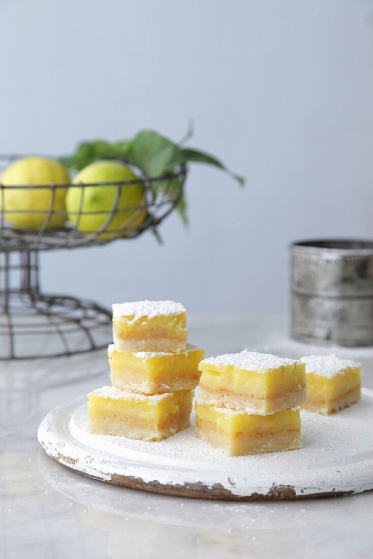 Lemon slices with a wire basket of lemons in the background