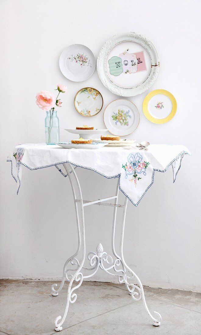 Cheesecakes on white table below decorative plates on the wall