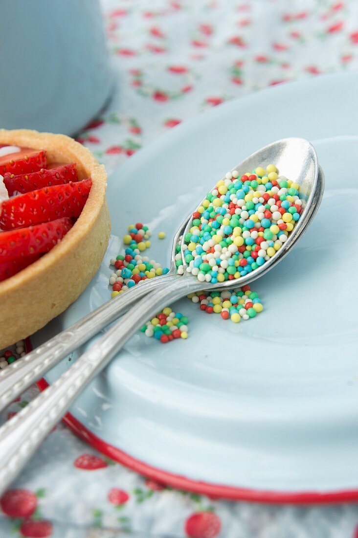 Colourful sugar sprinkles on a silver spoon