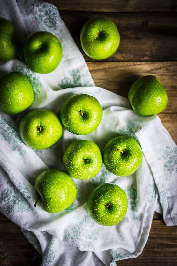 Bright green apples on wooden surface