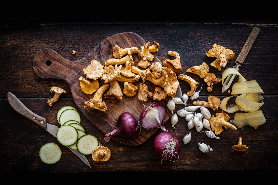 An arrangement of chanterelle mushrooms, red onions, pearl onions and cucumber slices