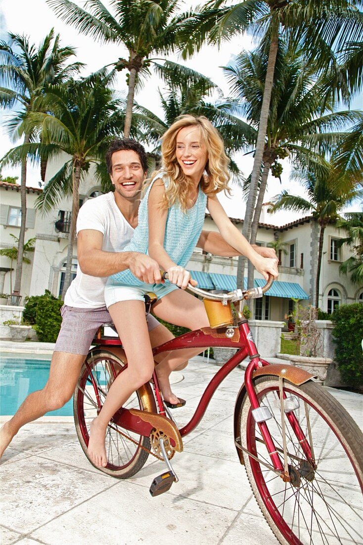A young couple sitting on a bike together