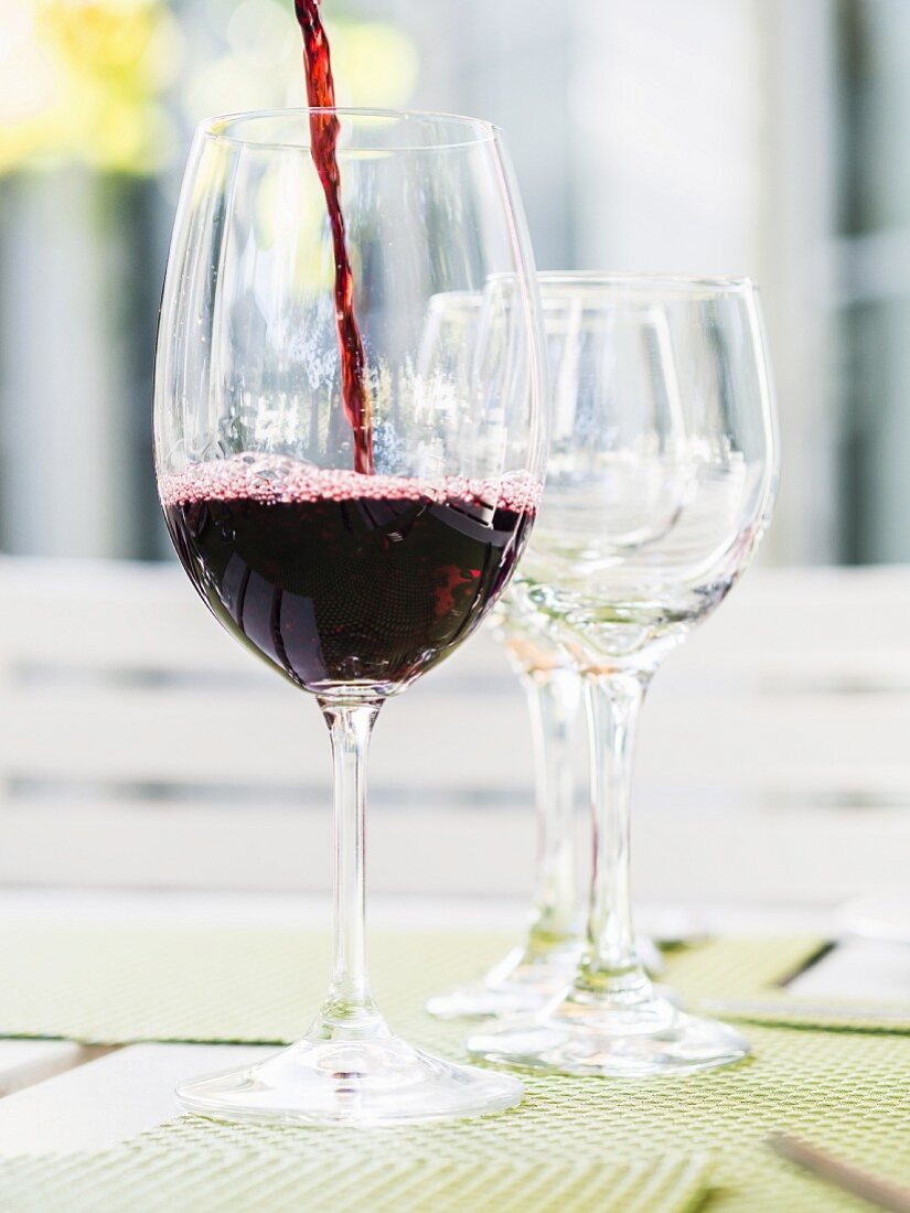 Rotwein aus Südafrika in ein Glas gießen