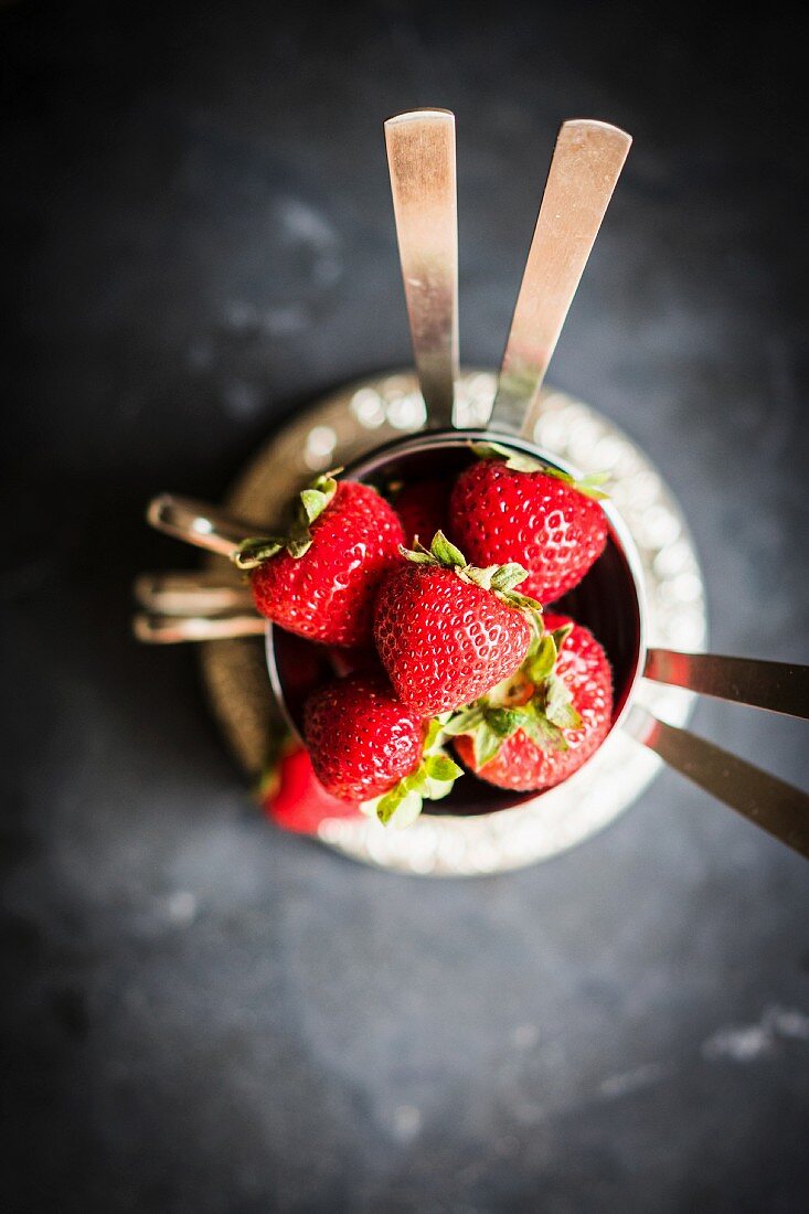 Fresh strawberries in silver bowls