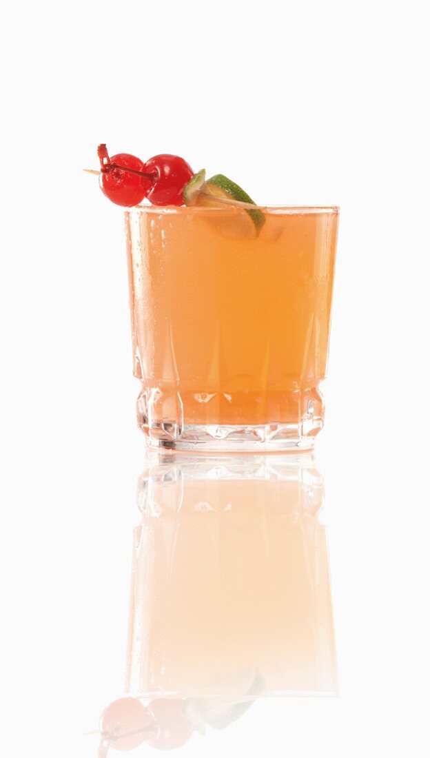Ein Cocktail mit Cocktailspiesschen vor weißem Hintergrund