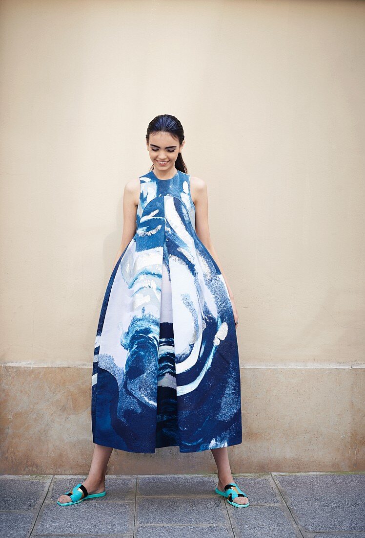 A young woman wearing a wide blue-and-white dress