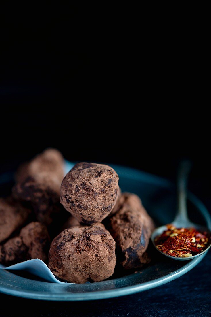 Homemade chocolate chilli truffles and a spoonful of dried chilli flakes