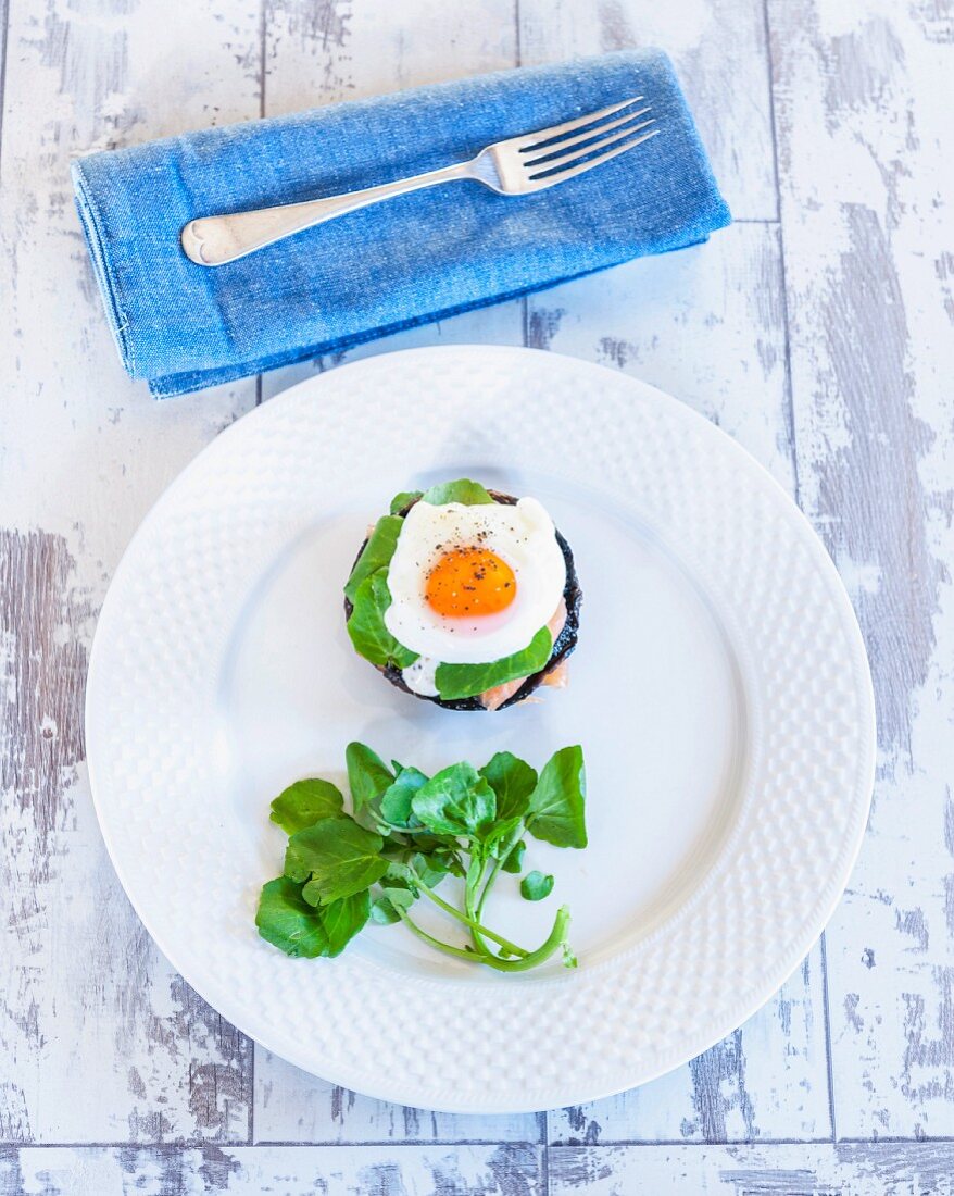 A stack of poached egg and salmon on mushrooms with watercress