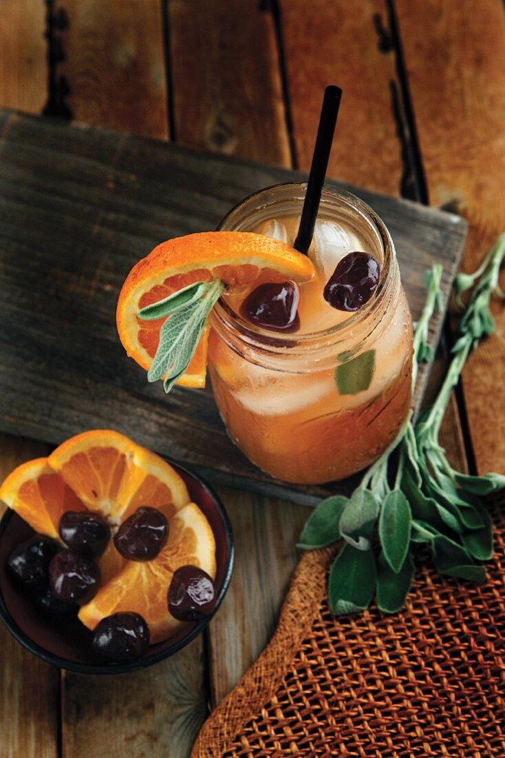 Apfel-Bourbon-Cocktail mit Orangen und Kirschen