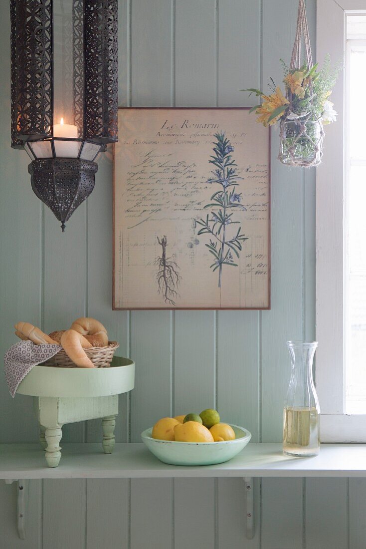 Croissants, fruit and carafe on bracket shelf on board wall