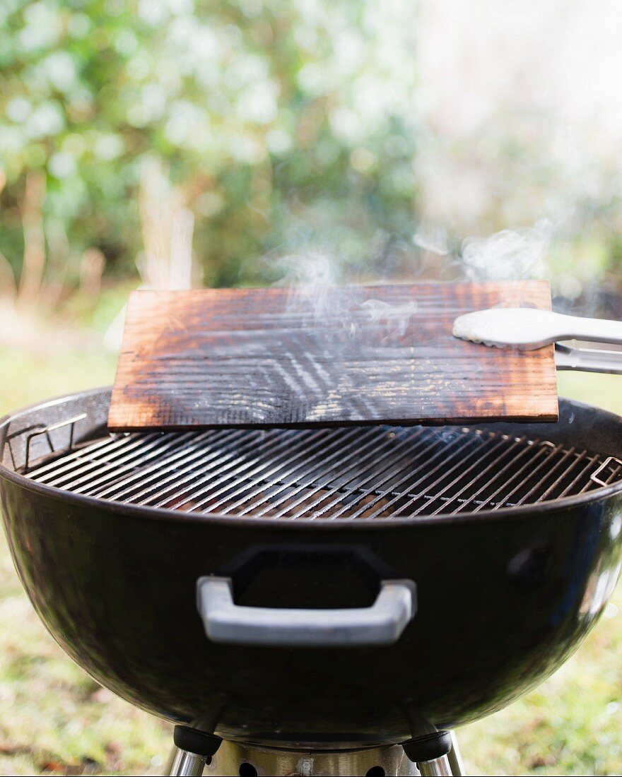 A cedar wood plank on a barbecue