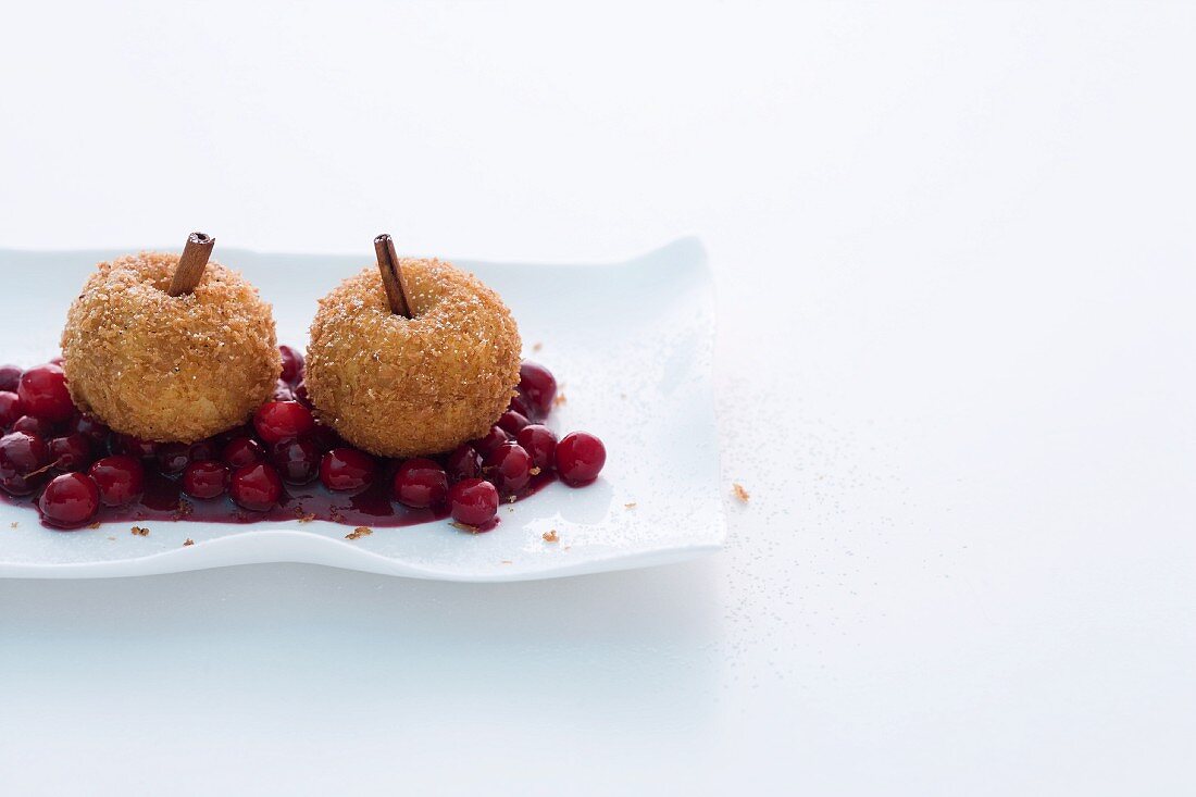 Breaded apple dumplings on cranberry compote