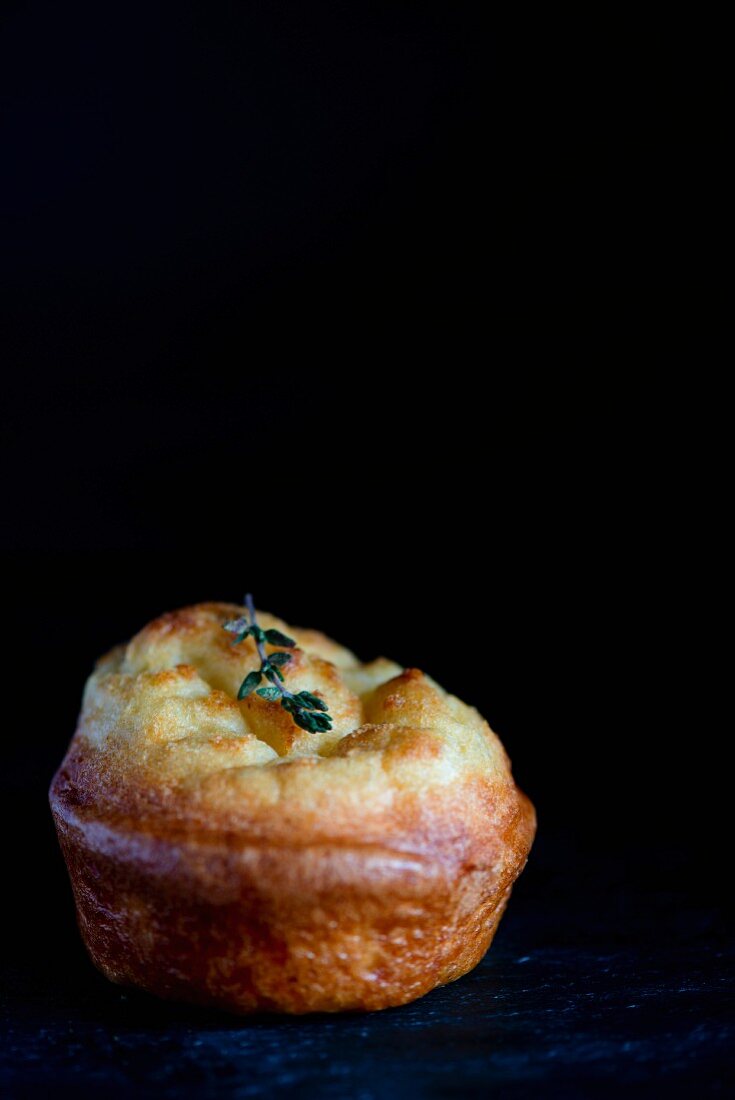 A Yorkshire pudding on a slate platter against a black background